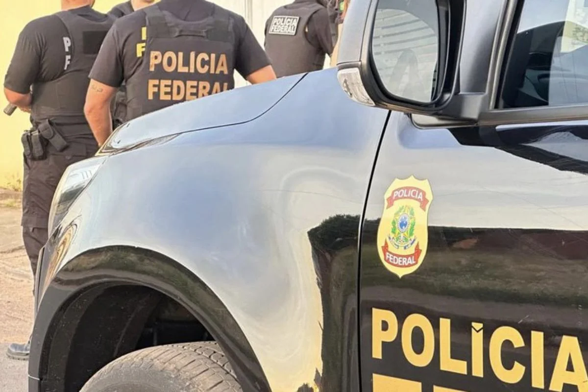 Foto colorida de policias federais e viatura - Metrópoles
