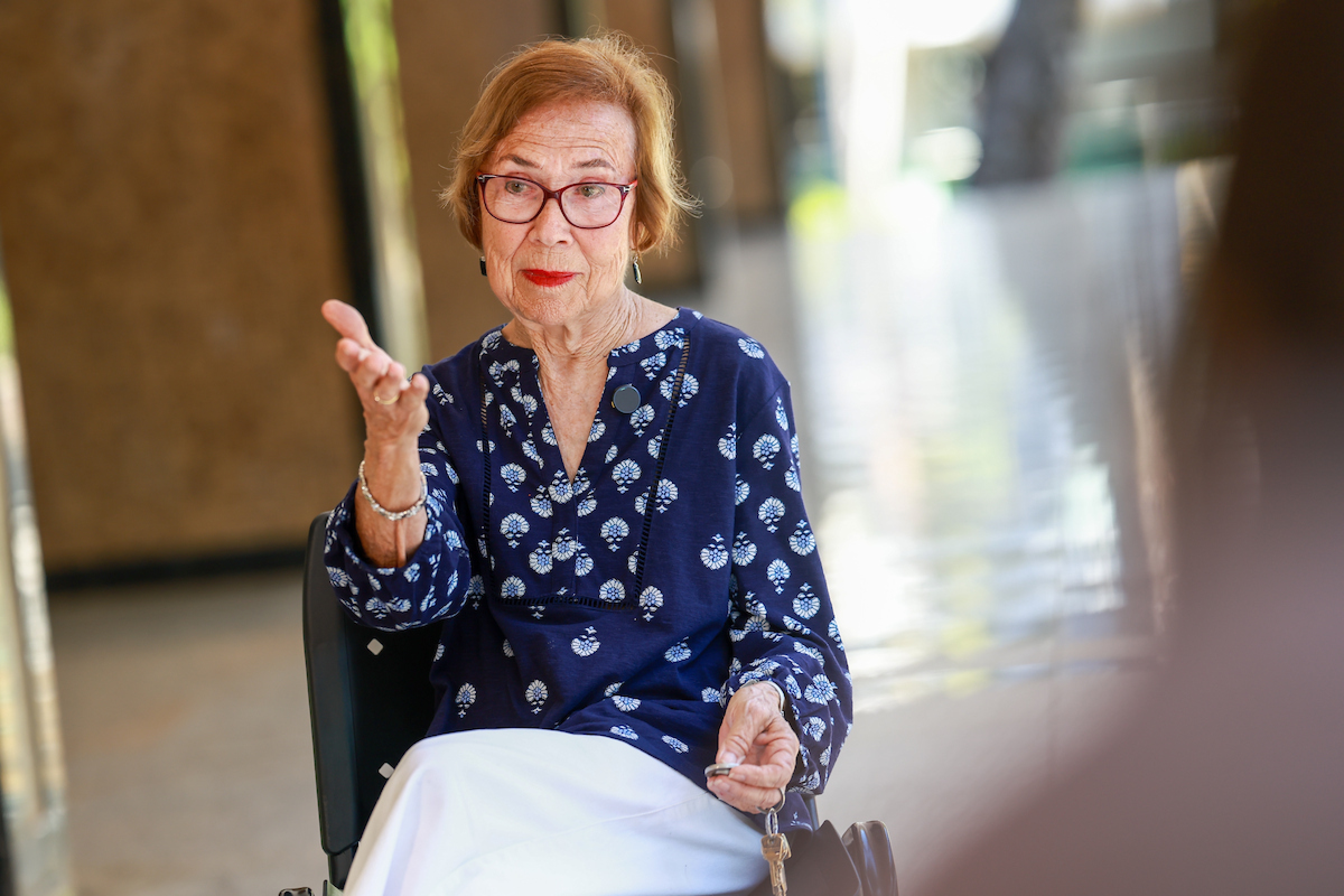 Imagem mostra mulher idosa com camisa azul conversando - Metrópoles